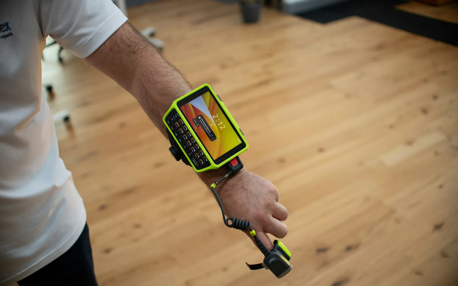 Worker wearing a rugged wrist-mounted mobile computer with a ring scanner