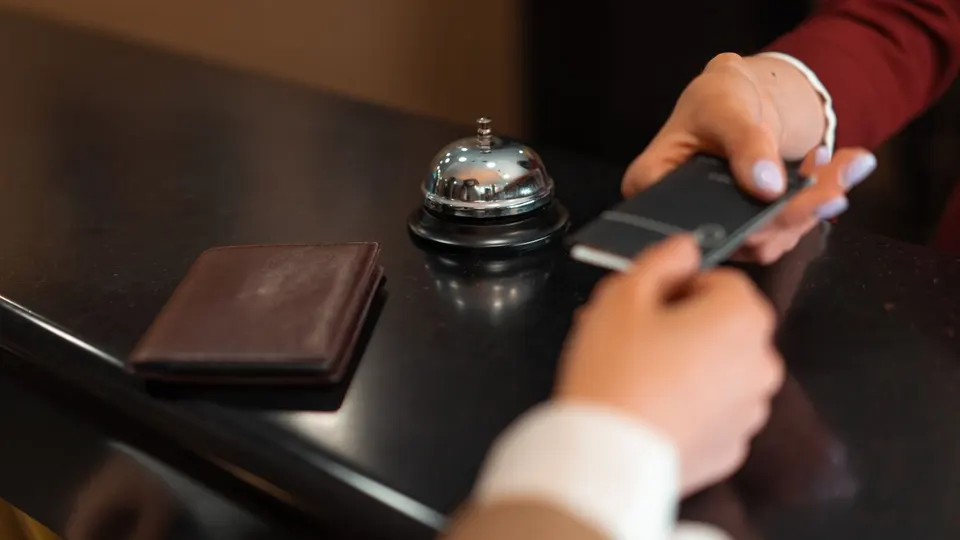 Guest paying by phone at a hotel front desk