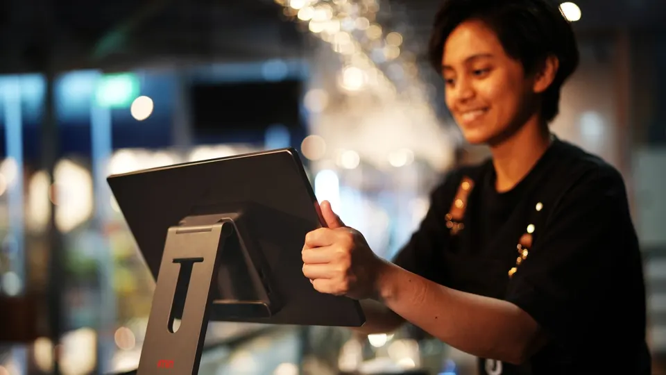 Restaurant cashier taking an order on a touchscreen