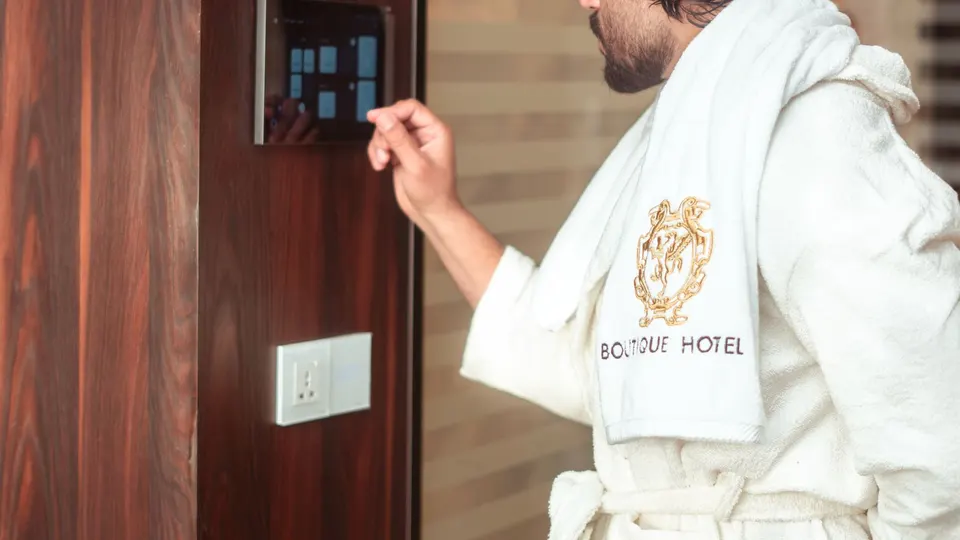 Hotel guest adjusting the room from a smart control panel