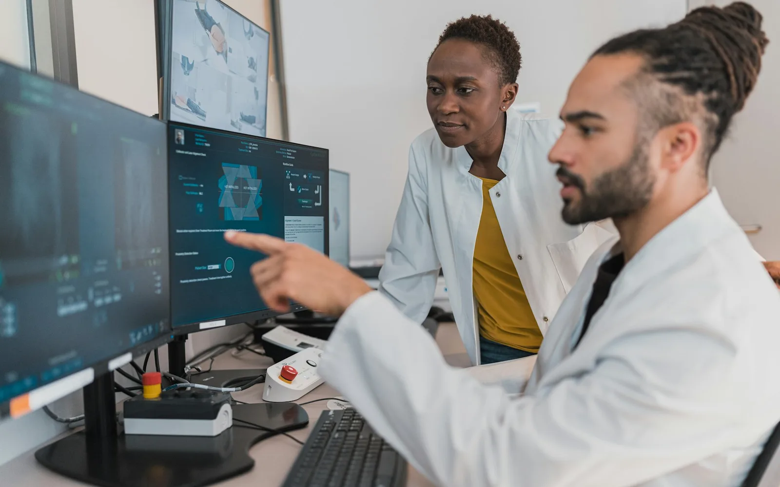 Clinicians reviewing patient imaging on hospital workstation monitors